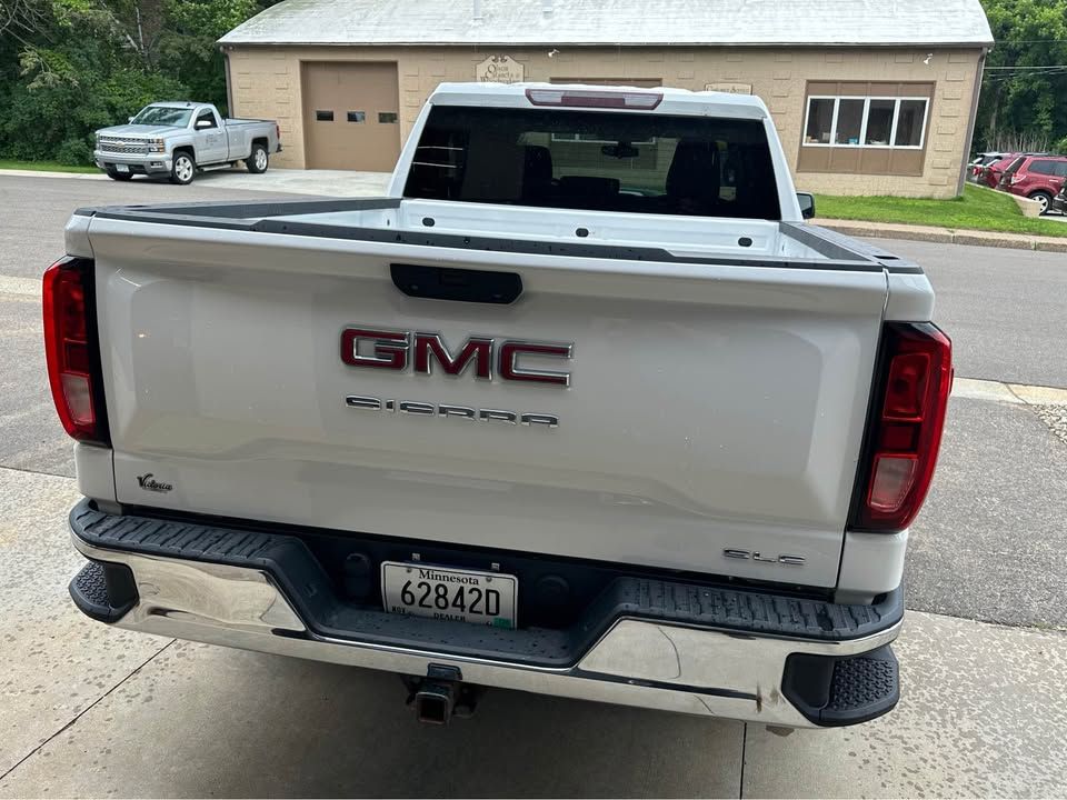 A white gmc truck is parked on the side of the road.
