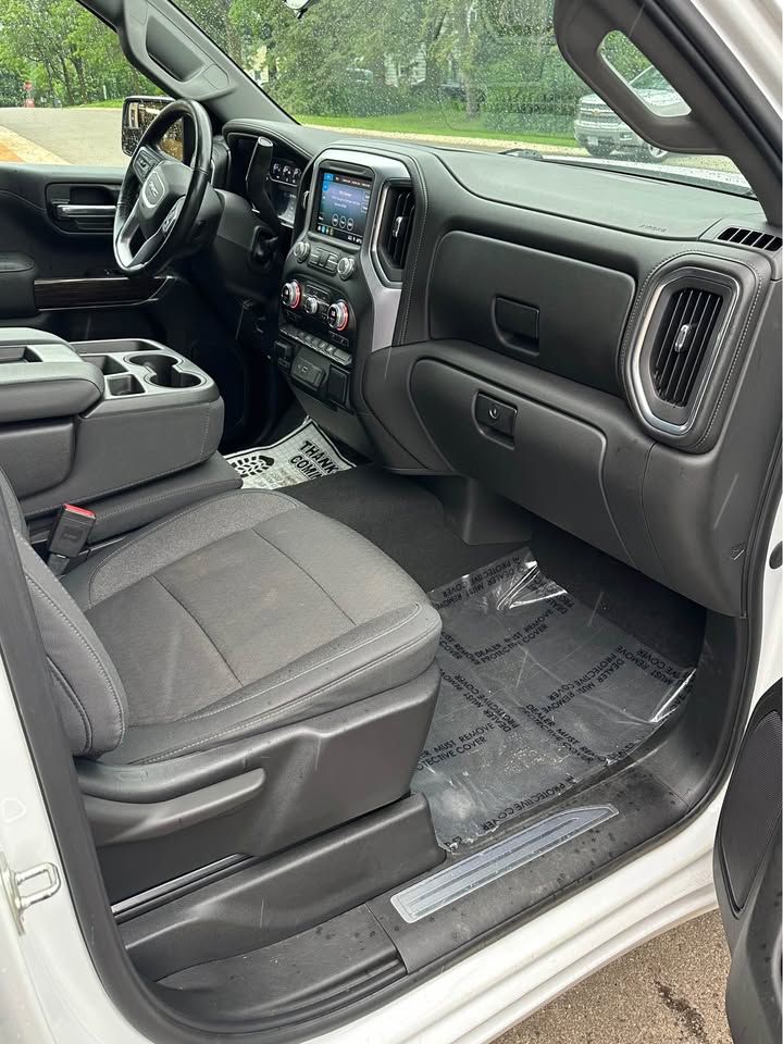 The interior of a white truck with the door open.