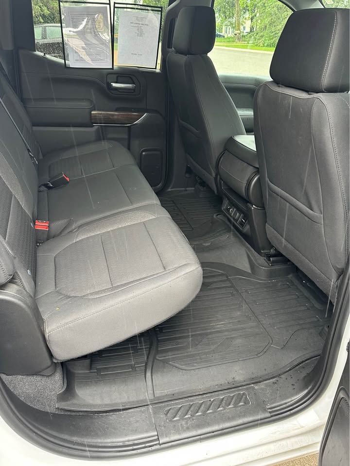 The back seat of a white truck with black seats.