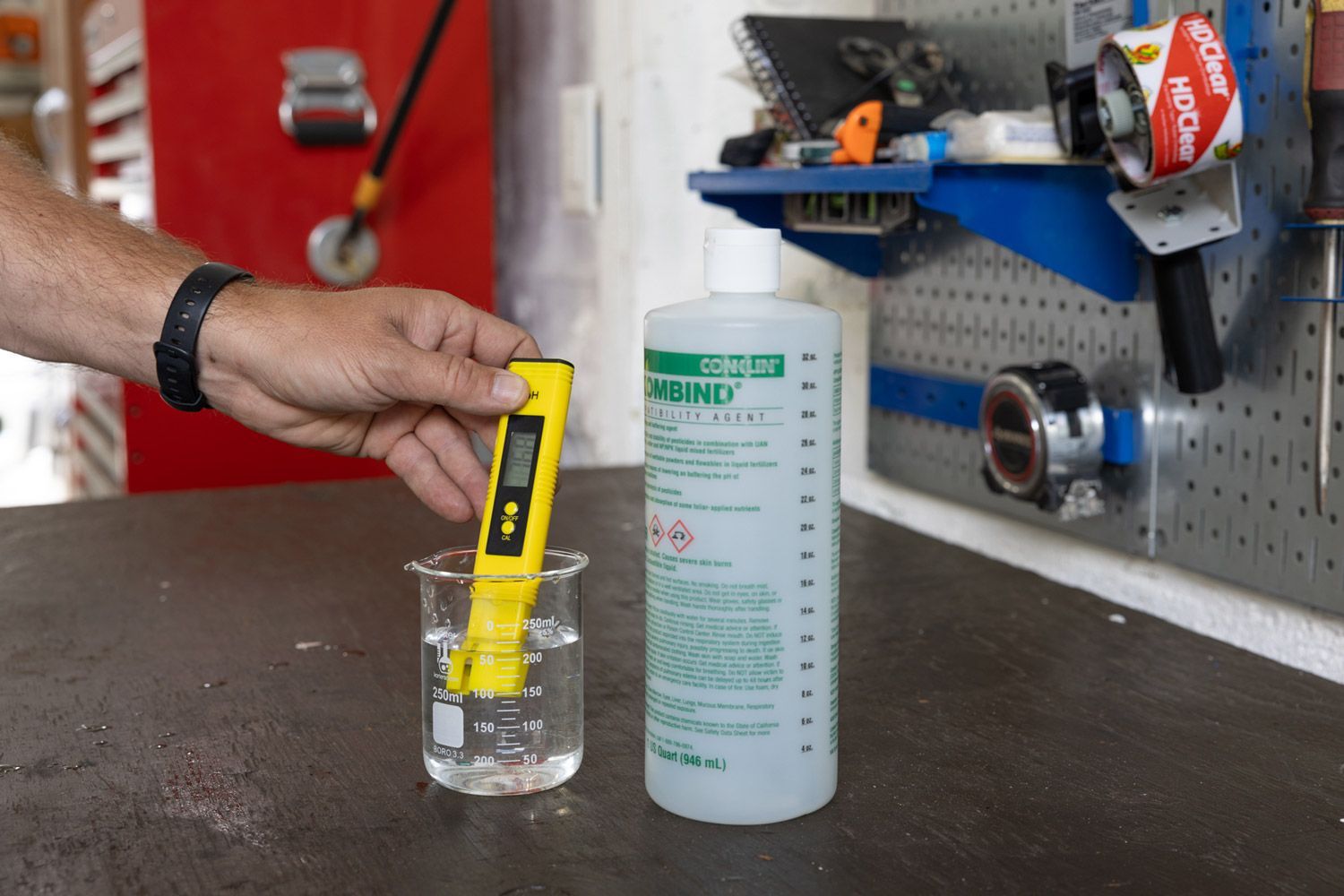 A person is measuring the ph of a liquid in a beaker