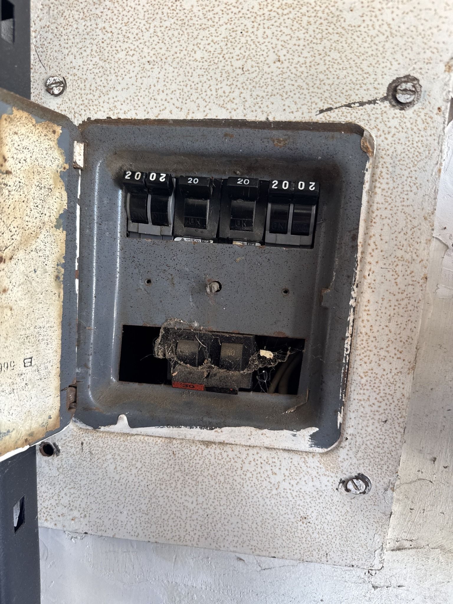 Open electrical panel with melted and charred components.