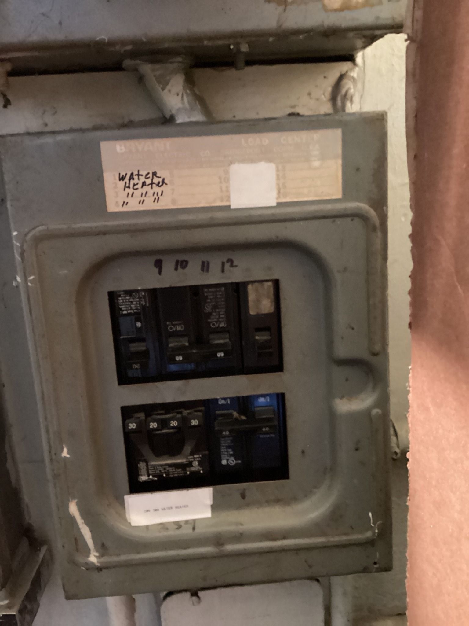 Electrical breaker box with open door, breakers visible.