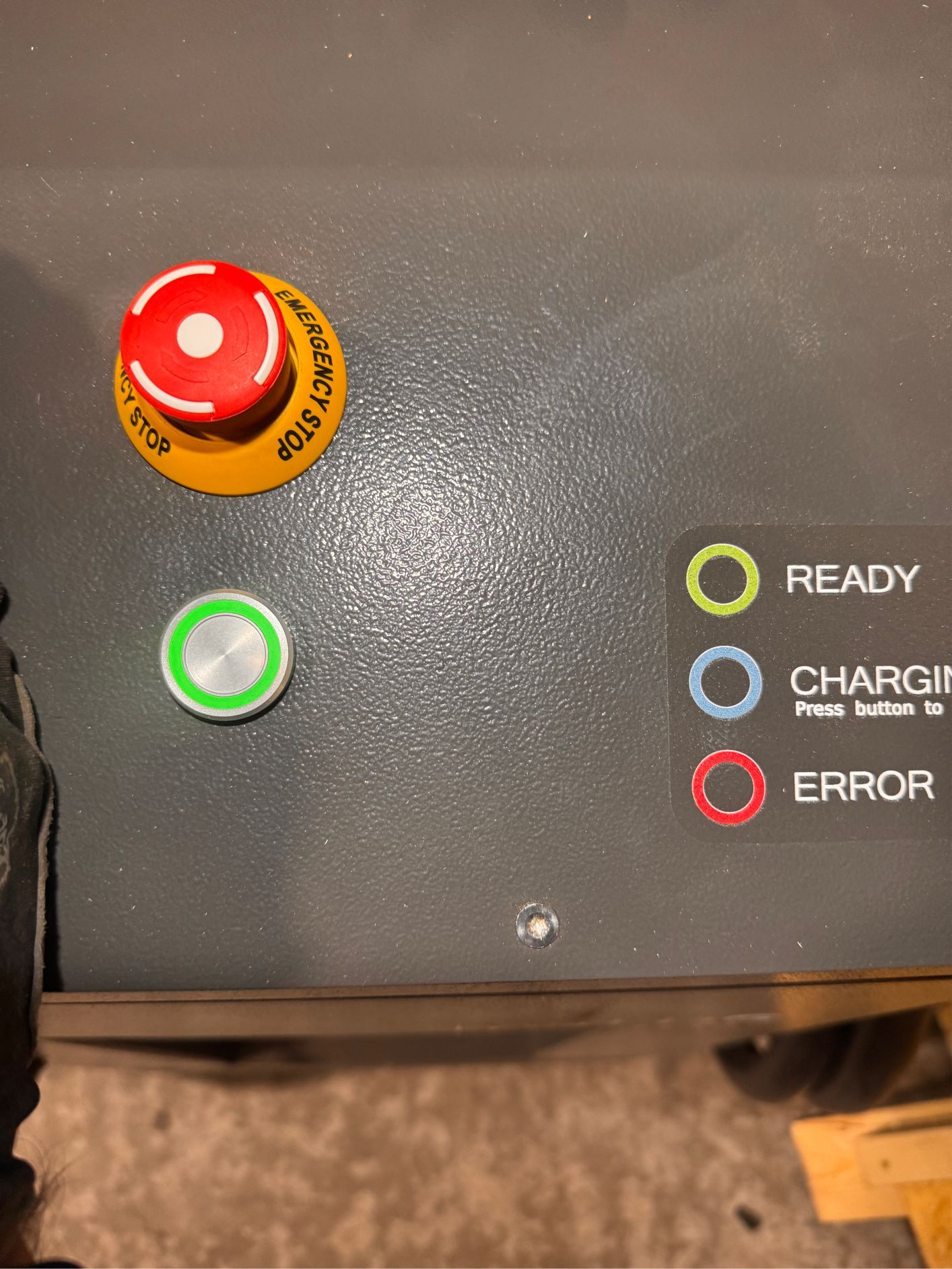 Control panel with emergency stop, green button, and status lights: ready, charging, error.