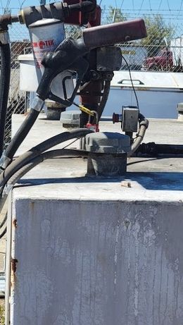 Fuel pump nozzle on top of a weathered storage tank.