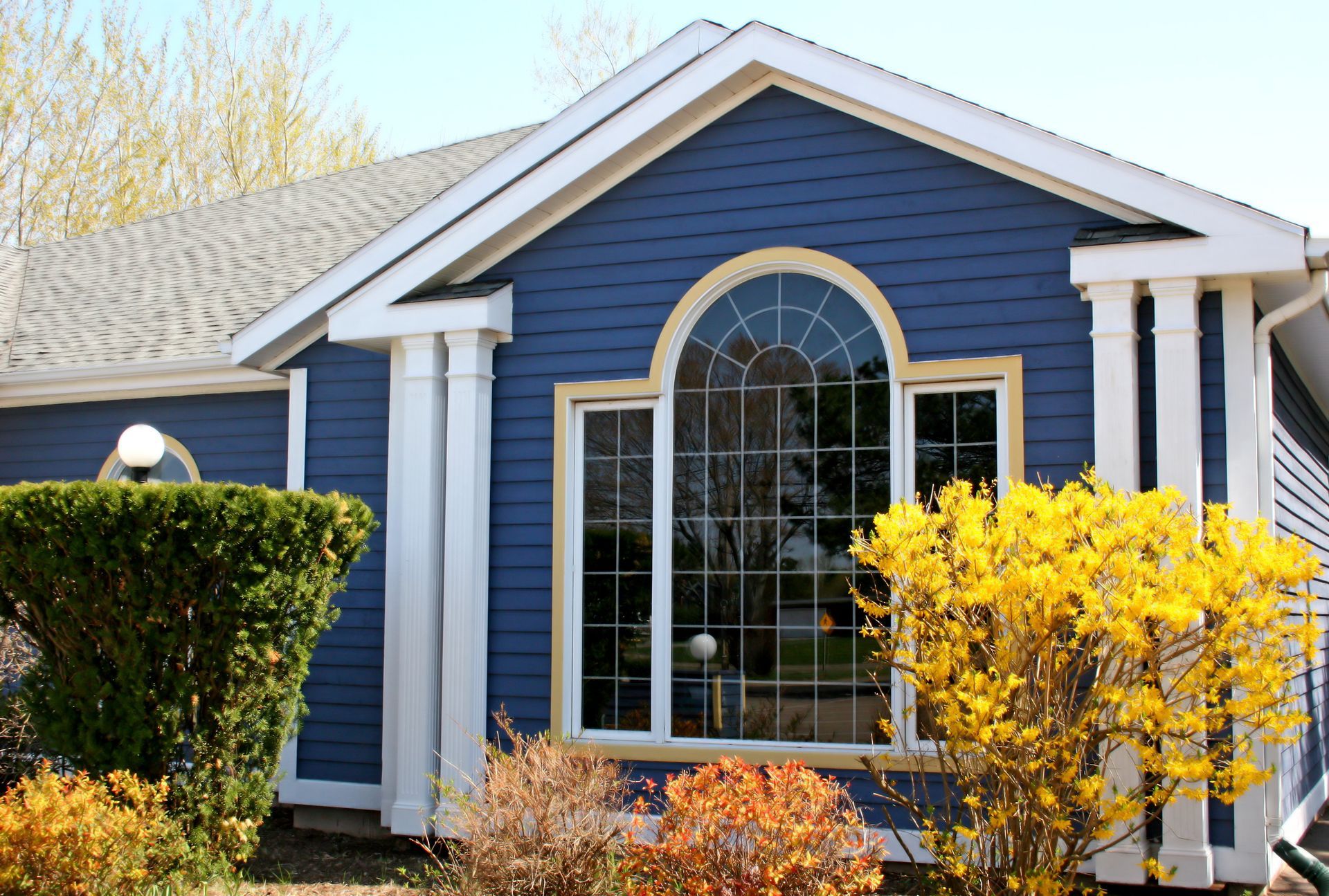 A blue and white house with a large window