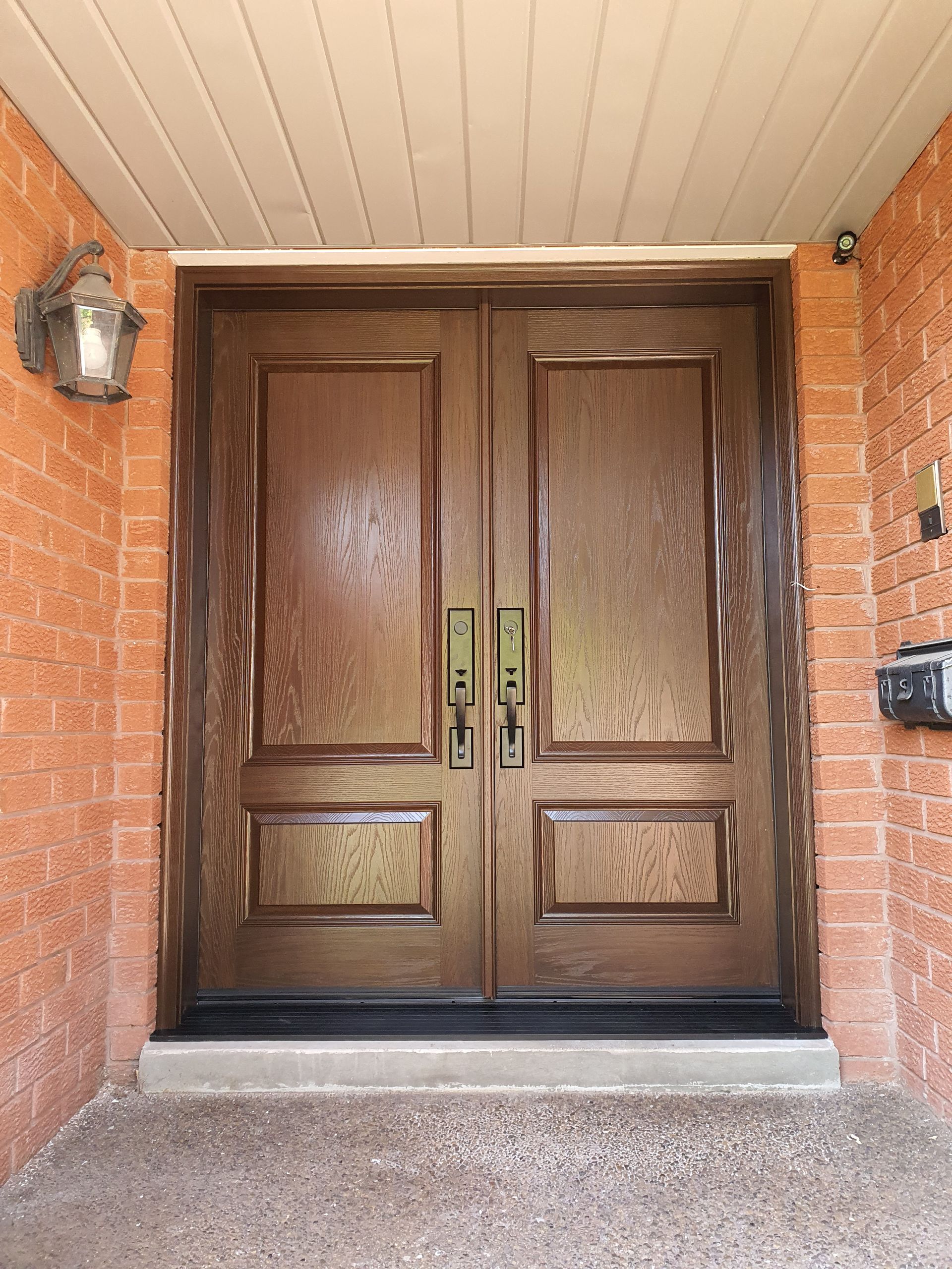 A large wooden door is sitting on top of a brick wall.