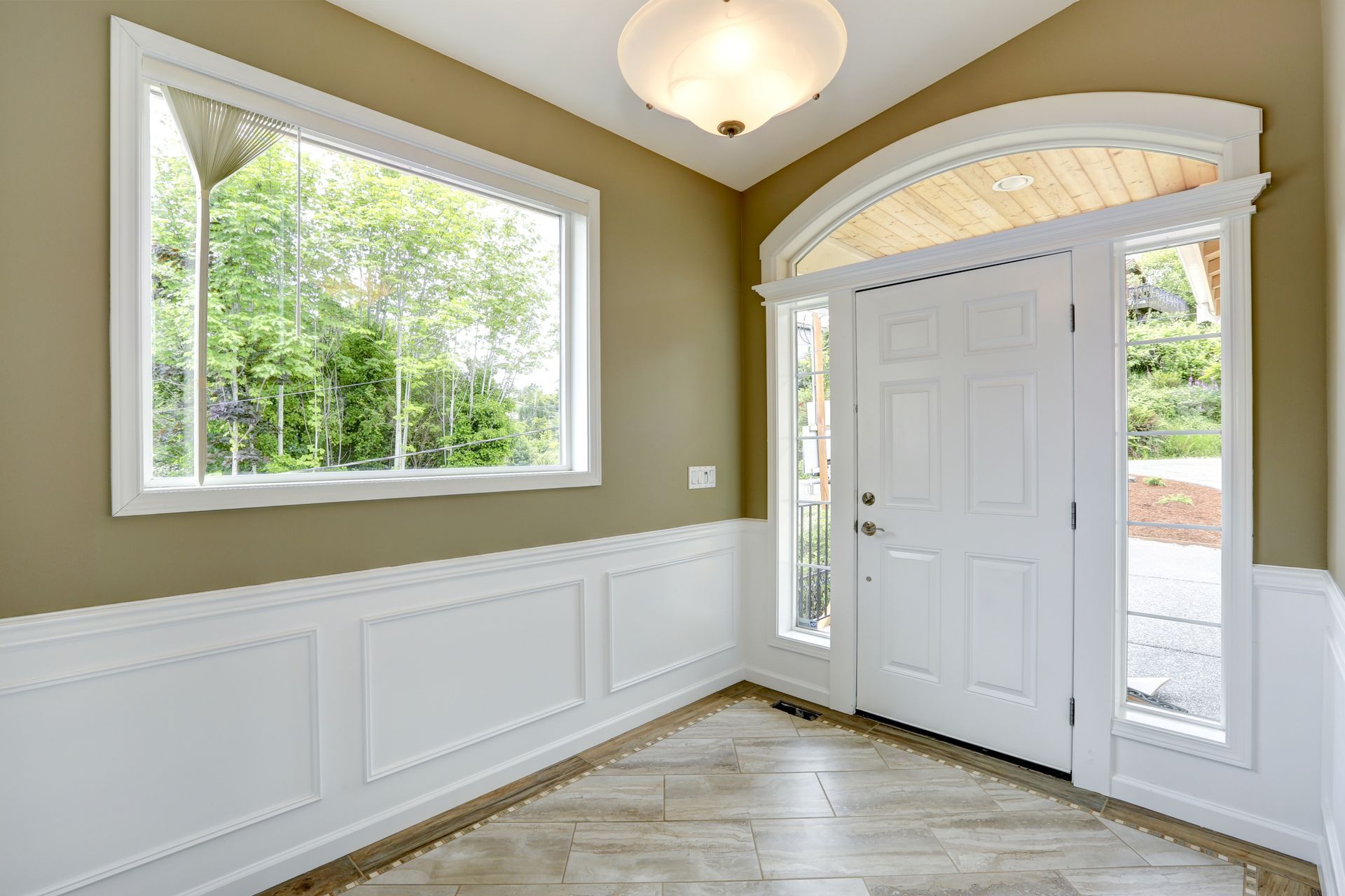 An empty hallway with a white door and two windows.