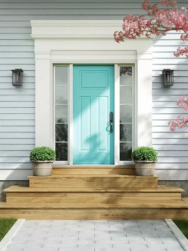 A blue front door with a white trim and a wooden porch.
