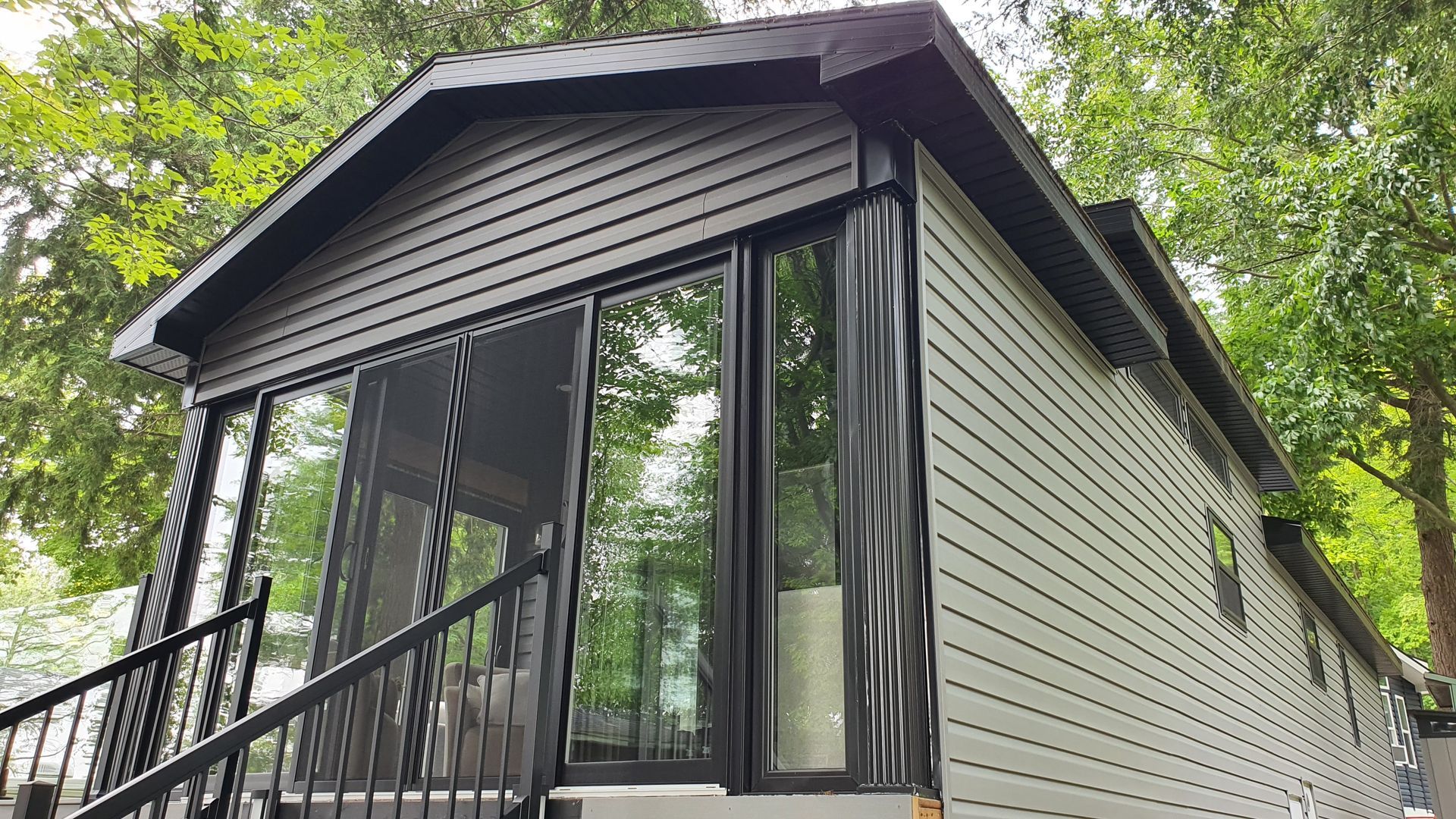 A small house with a screened in porch and stairs.