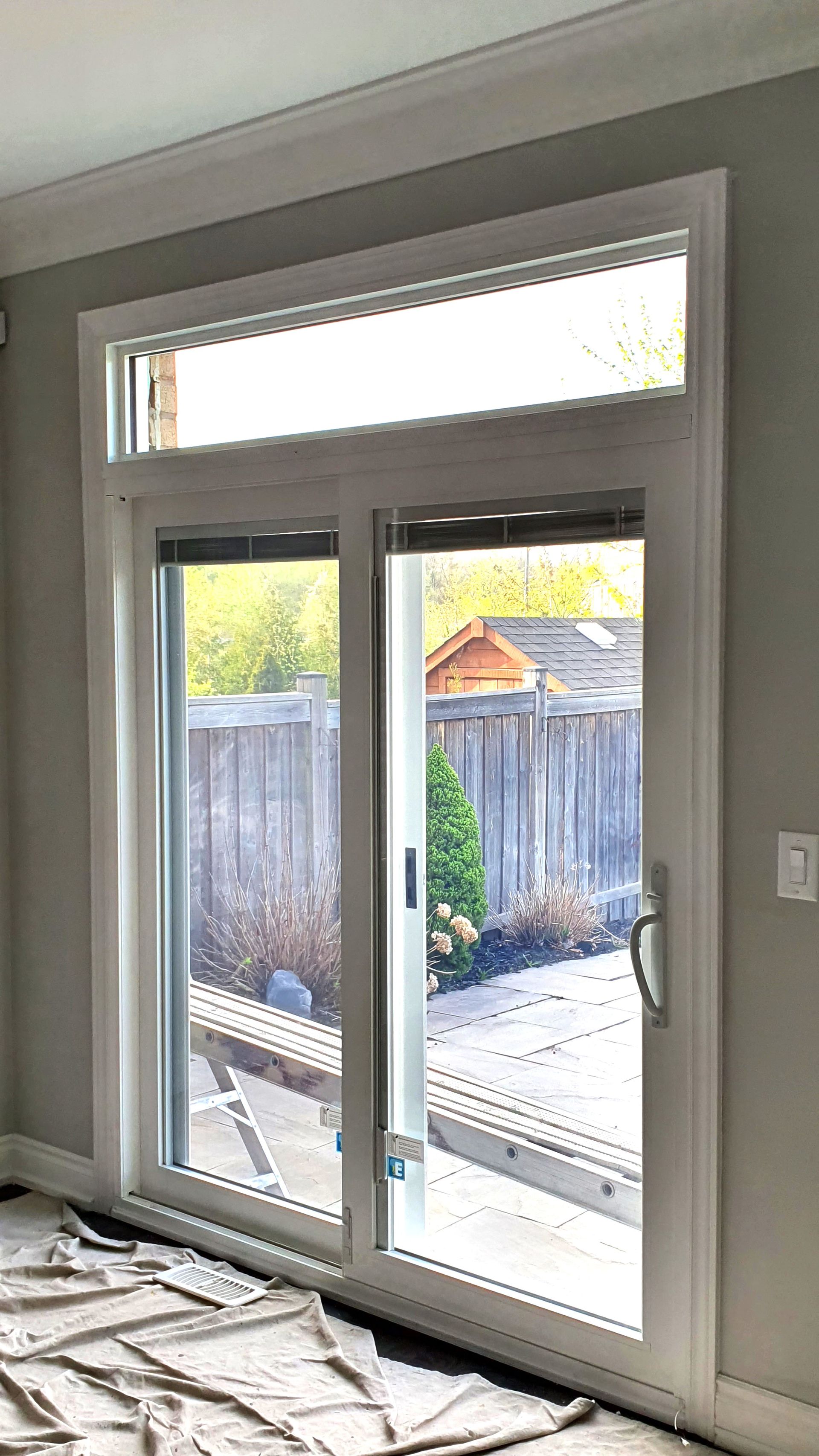 A room with a sliding glass door and a window.
