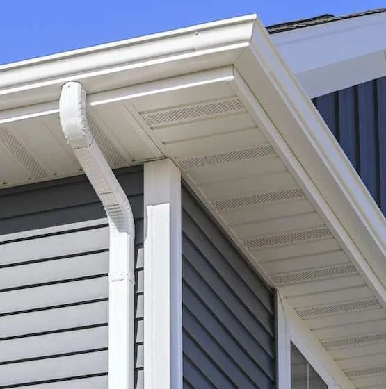 a house with white soffits, fascia and gutter on the side of it