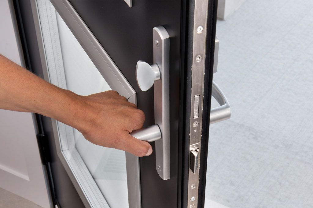 a person is opening a multi-lock door with their hand