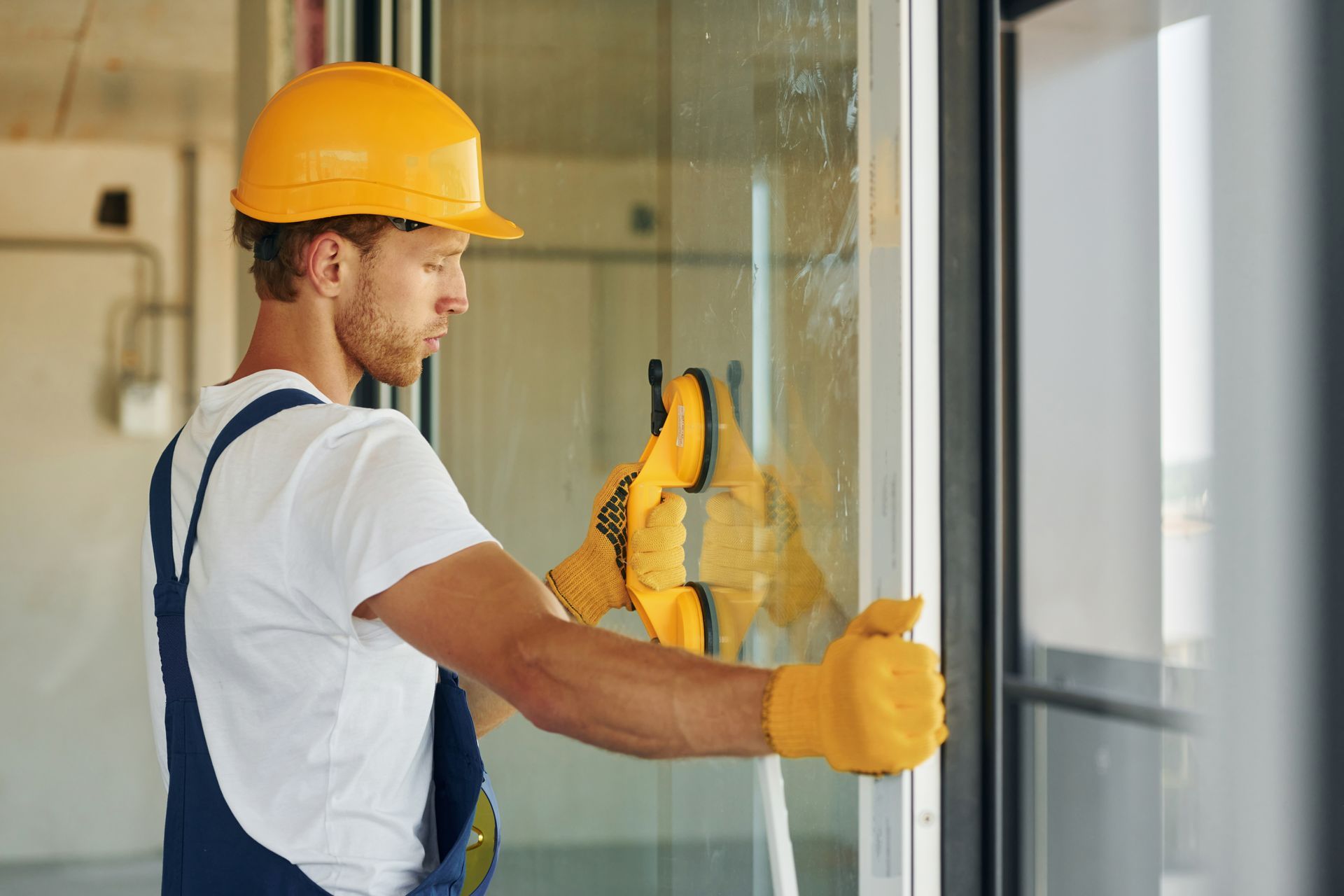 a man wearing a hard hat is working on a window
