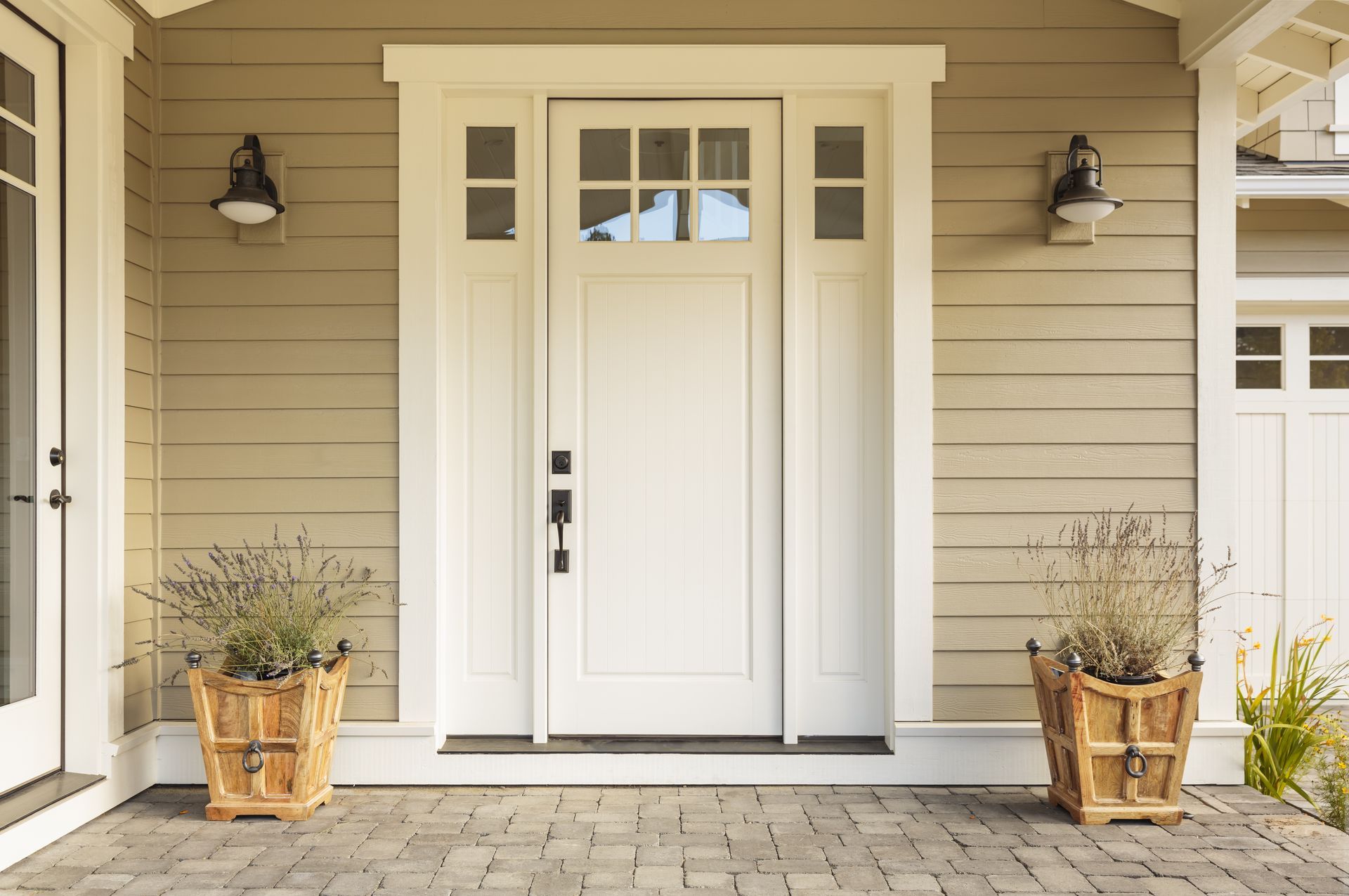 the front door of a house with two potted plants in front of it