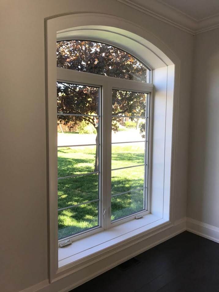 A large window in a room with a tree in the background.