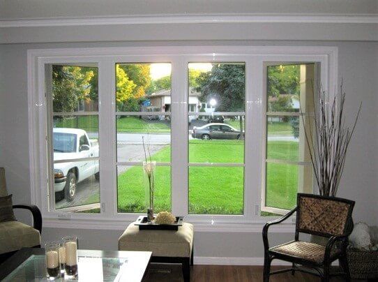 A living room with a lot of windows and a truck parked in the driveway