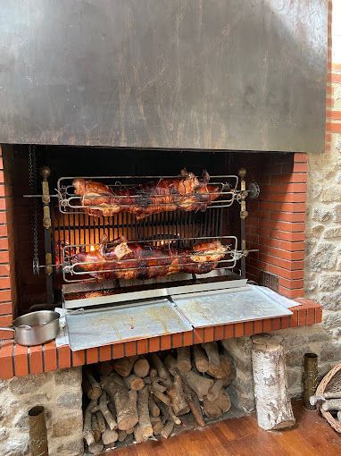 Deux poulets cuisent sur un gril dans une cheminée.
