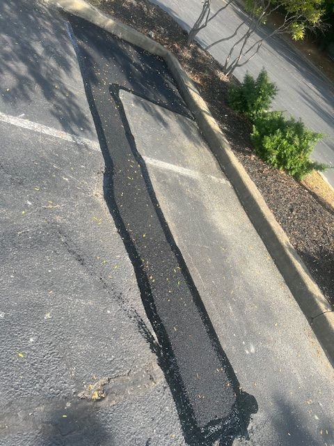 A Patch of Asphalt Is Being Applied to A Parking Lot.