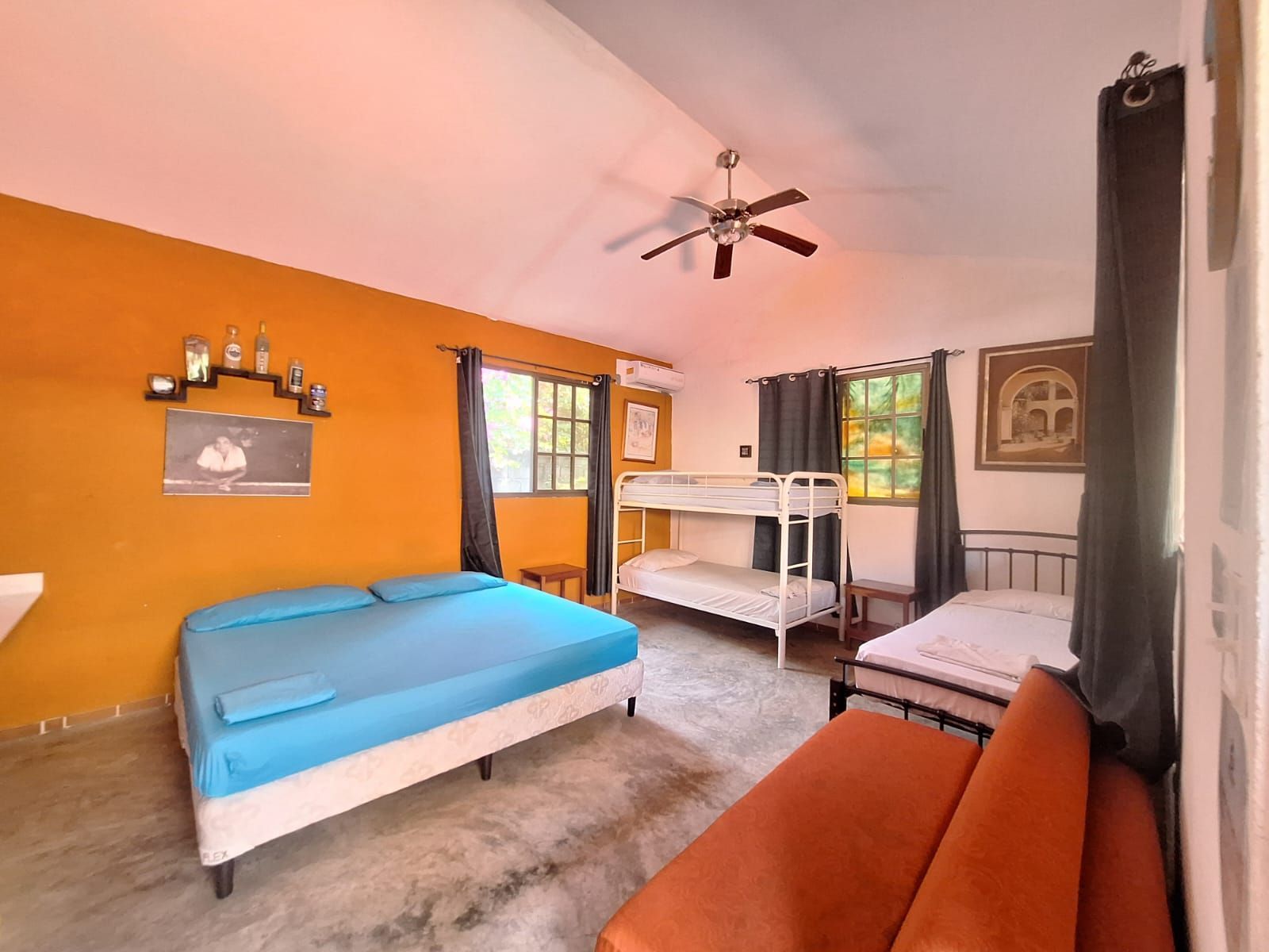 Un dormitorio con literas y ventilador de techo.