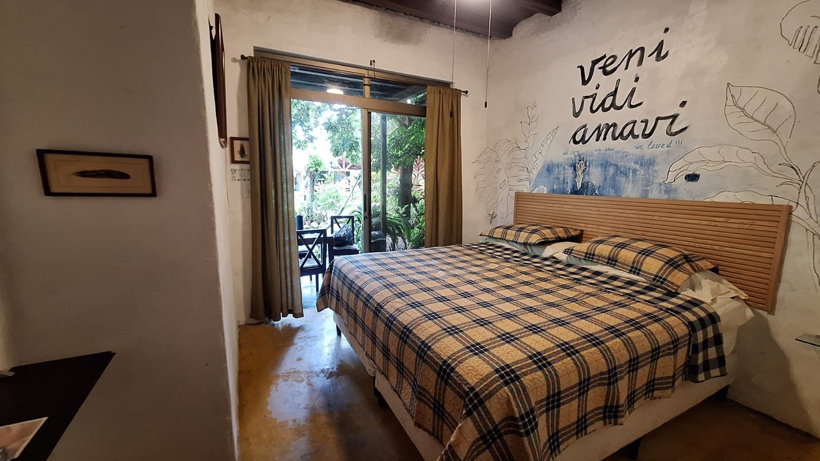 Un dormitorio con una cama y un cuadro en la pared que dice veni vidi amari.