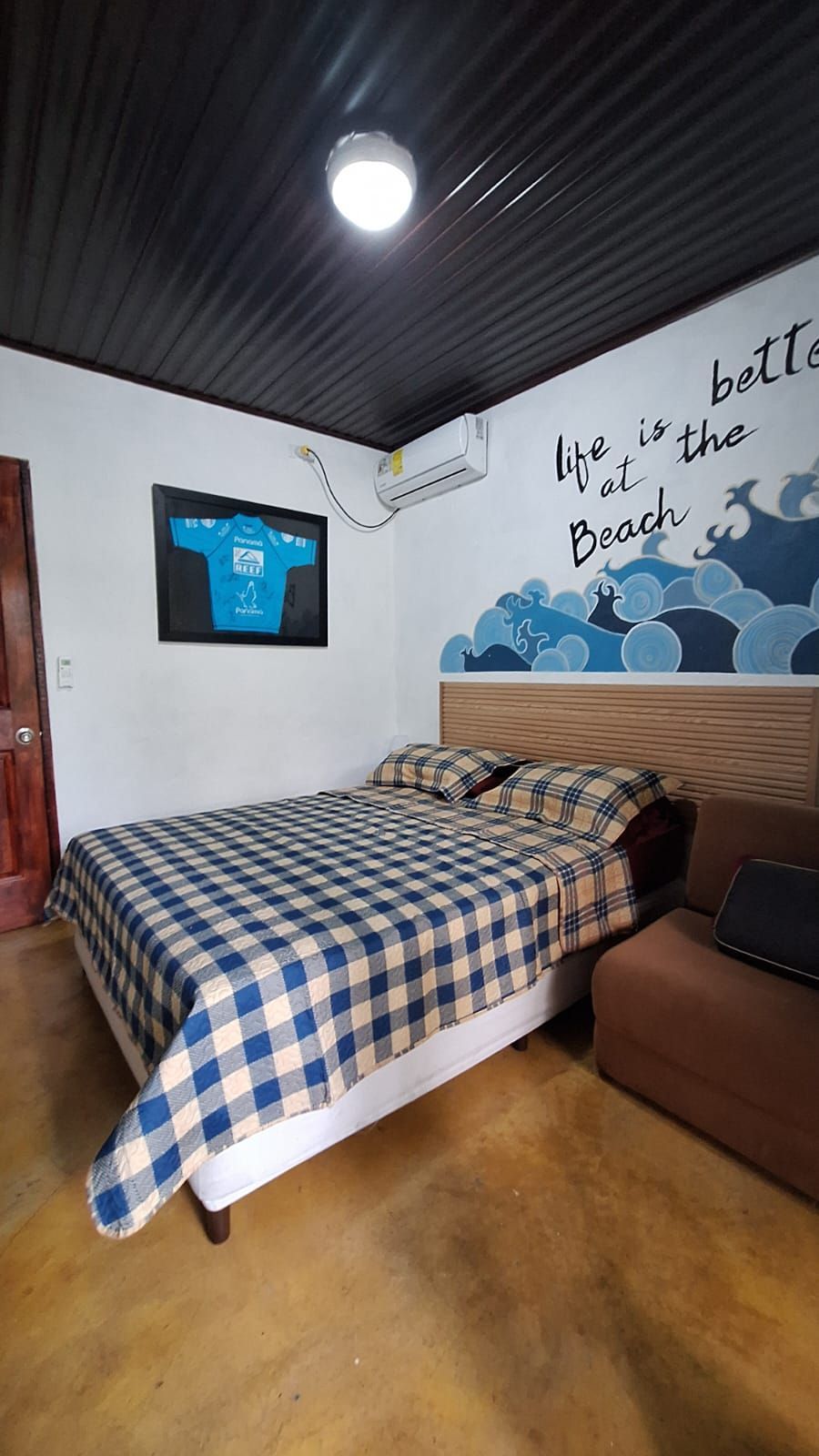 Un dormitorio con una cama y un cuadro en la pared.