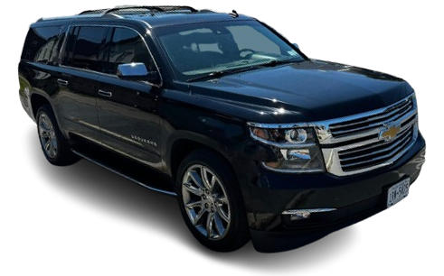 A black Chevrolet Suburban SUV parked at a slight angle, featuring chrome wheels and a chrome grille.