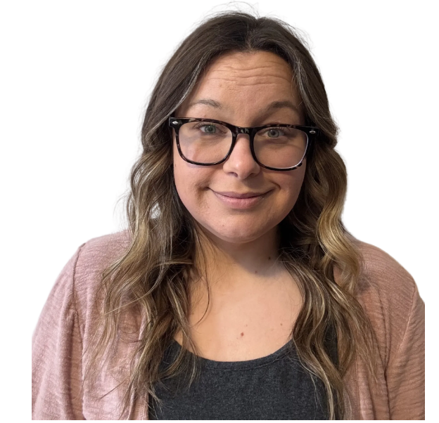 Woman wearing glasses and a pink cardigan smiles at the camera.