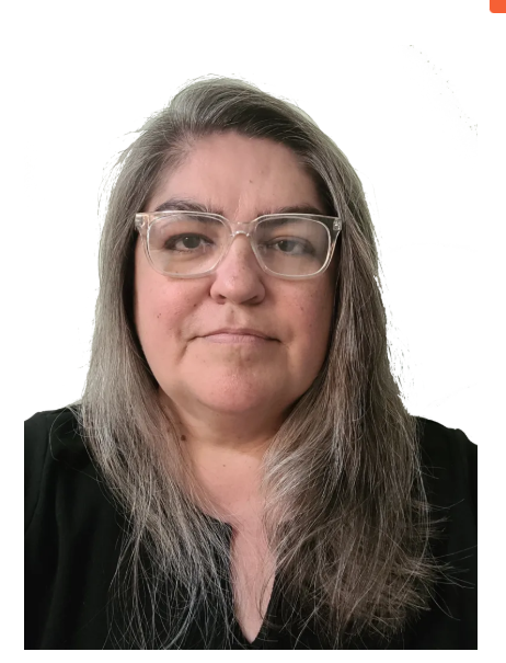 A person with shoulder-length gray hair and clear-framed glasses, wearing a black shirt against a white background.