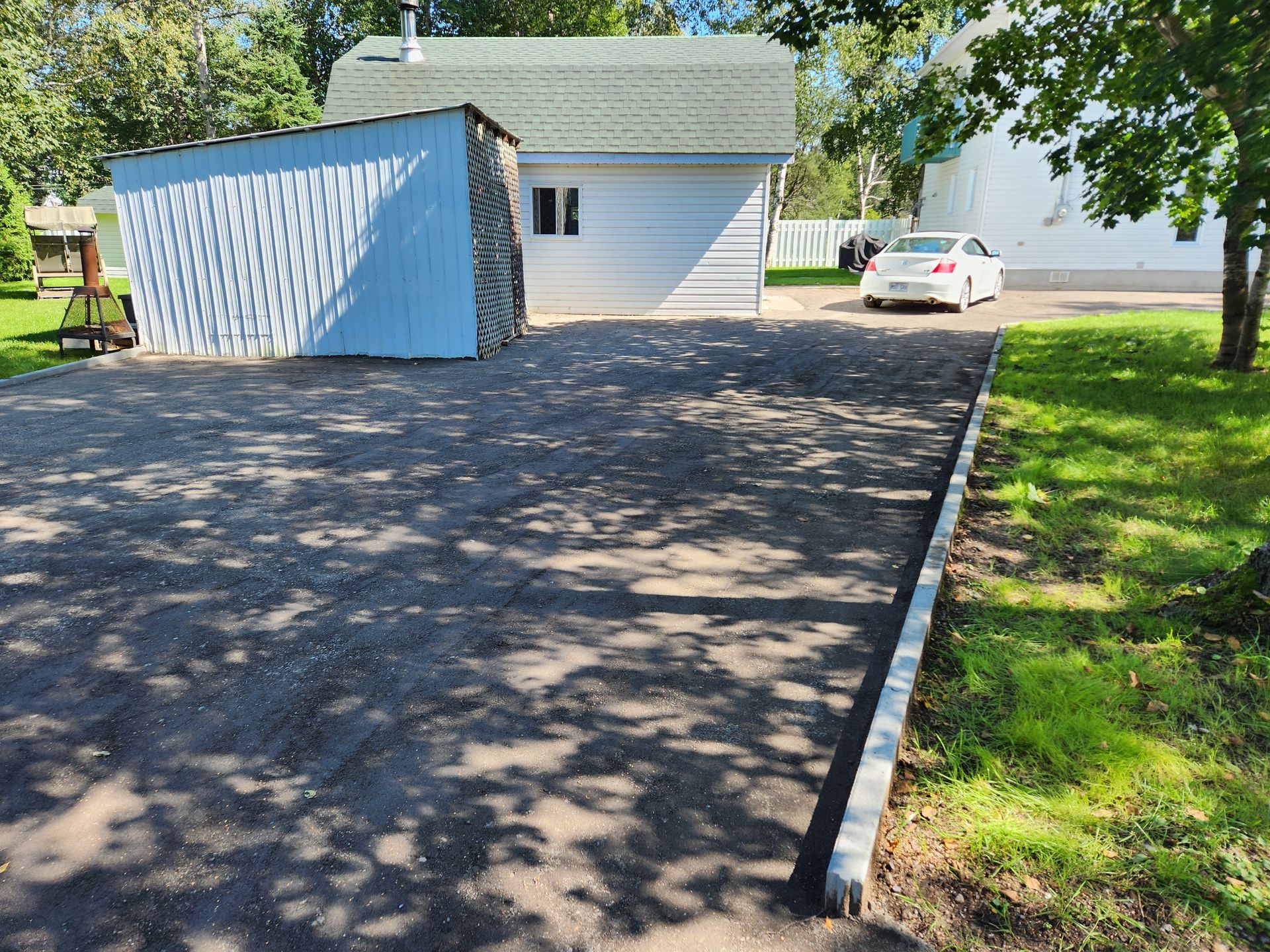 Une voiture est garée dans une allée à côté d'une maison.