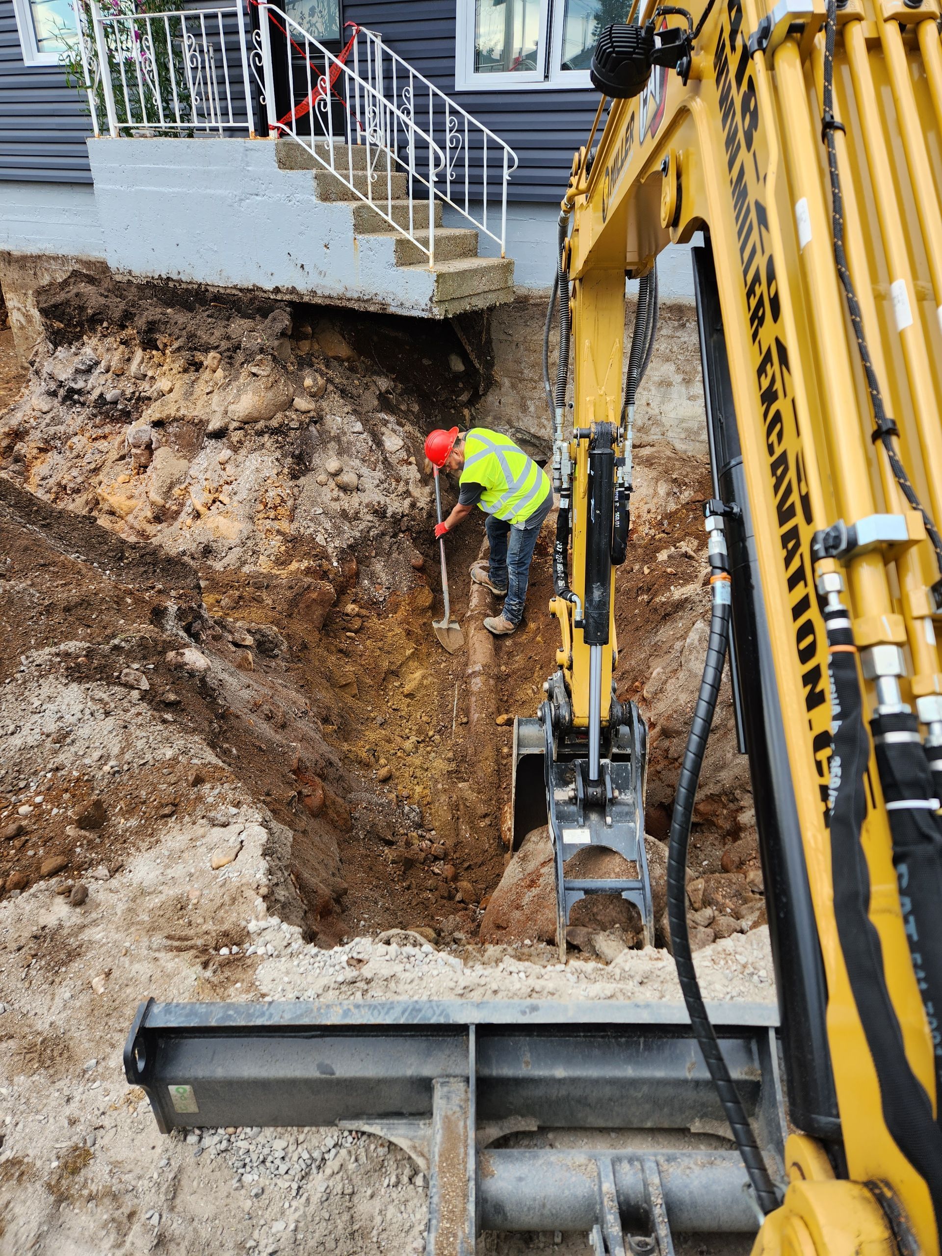 Une excavatrice jaune creuse un trou dans le sol