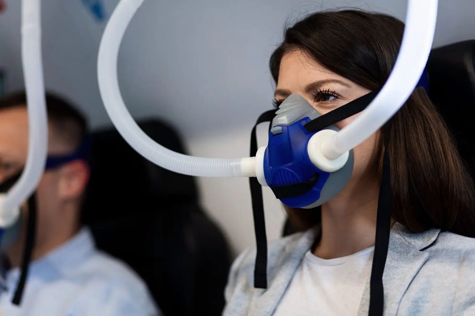 A woman is wearing an oxygen mask on a plane. Hbot have 14 conditions that are FDA approved 