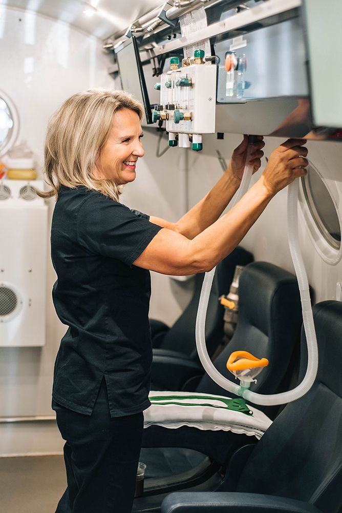 A woman is working on a machine in a room.