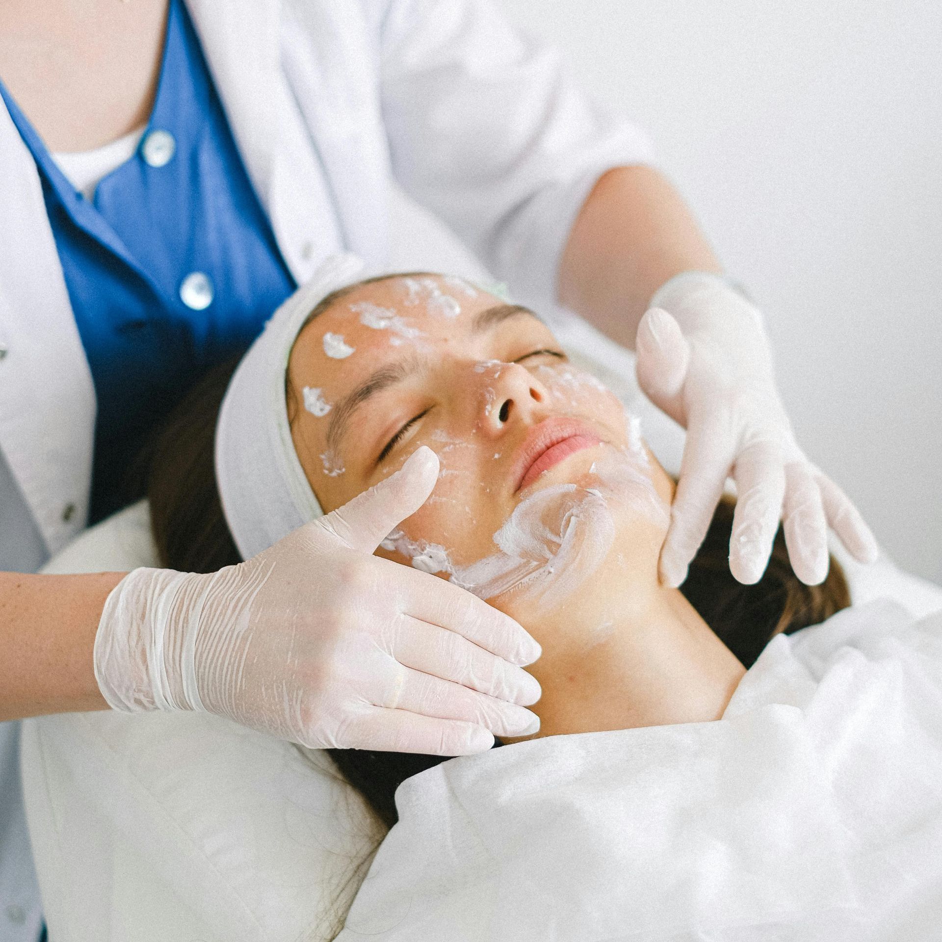 A woman receiving a facial treatment by a professional doctor