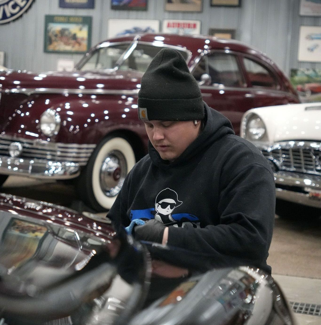 A man is working on an old car in a garage
