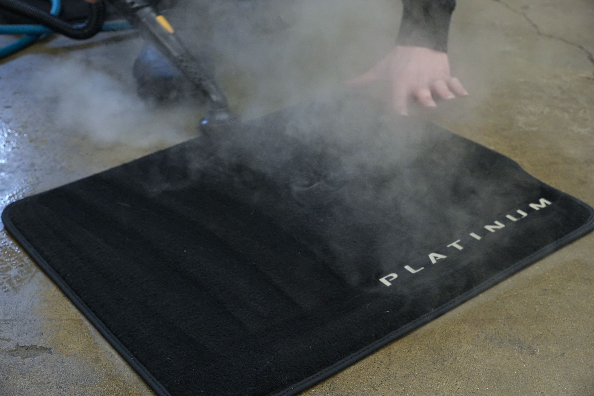 A person is cleaning a mat that says platinum on it