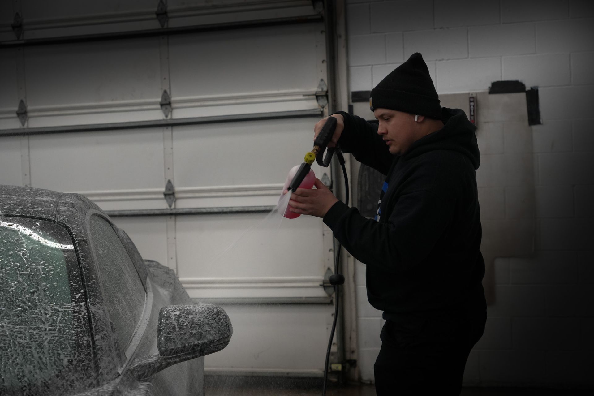 A man is cleaning a car with a spray bottle