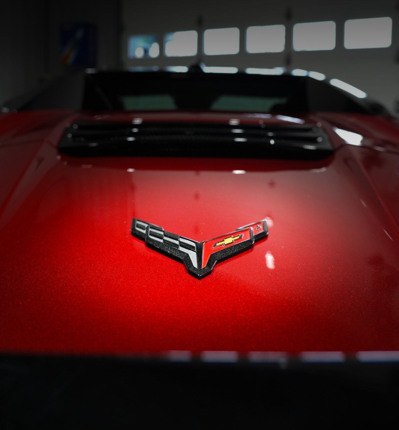 A close up of a red corvette hood emblem