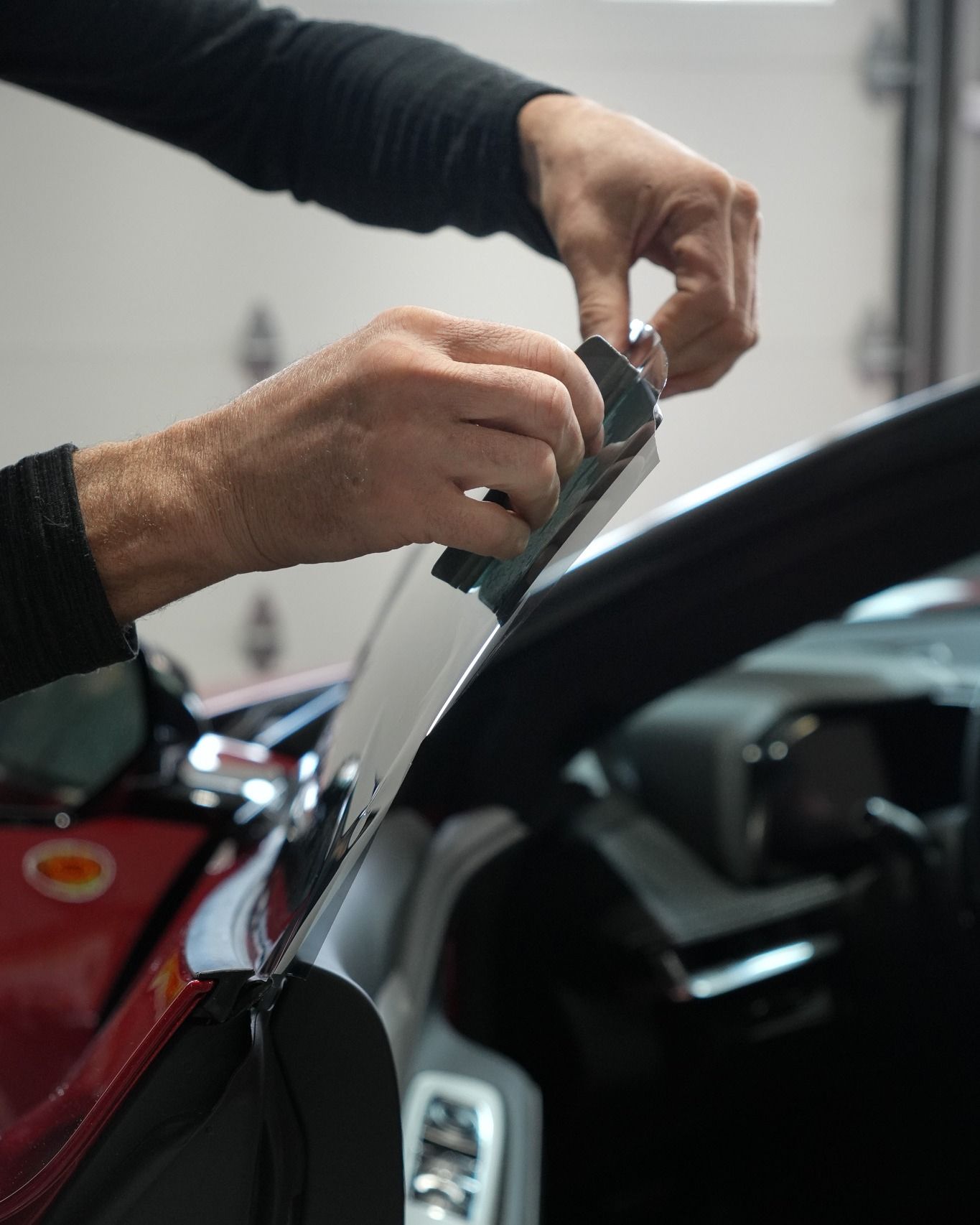 A close up of a person cleaning a car windshield