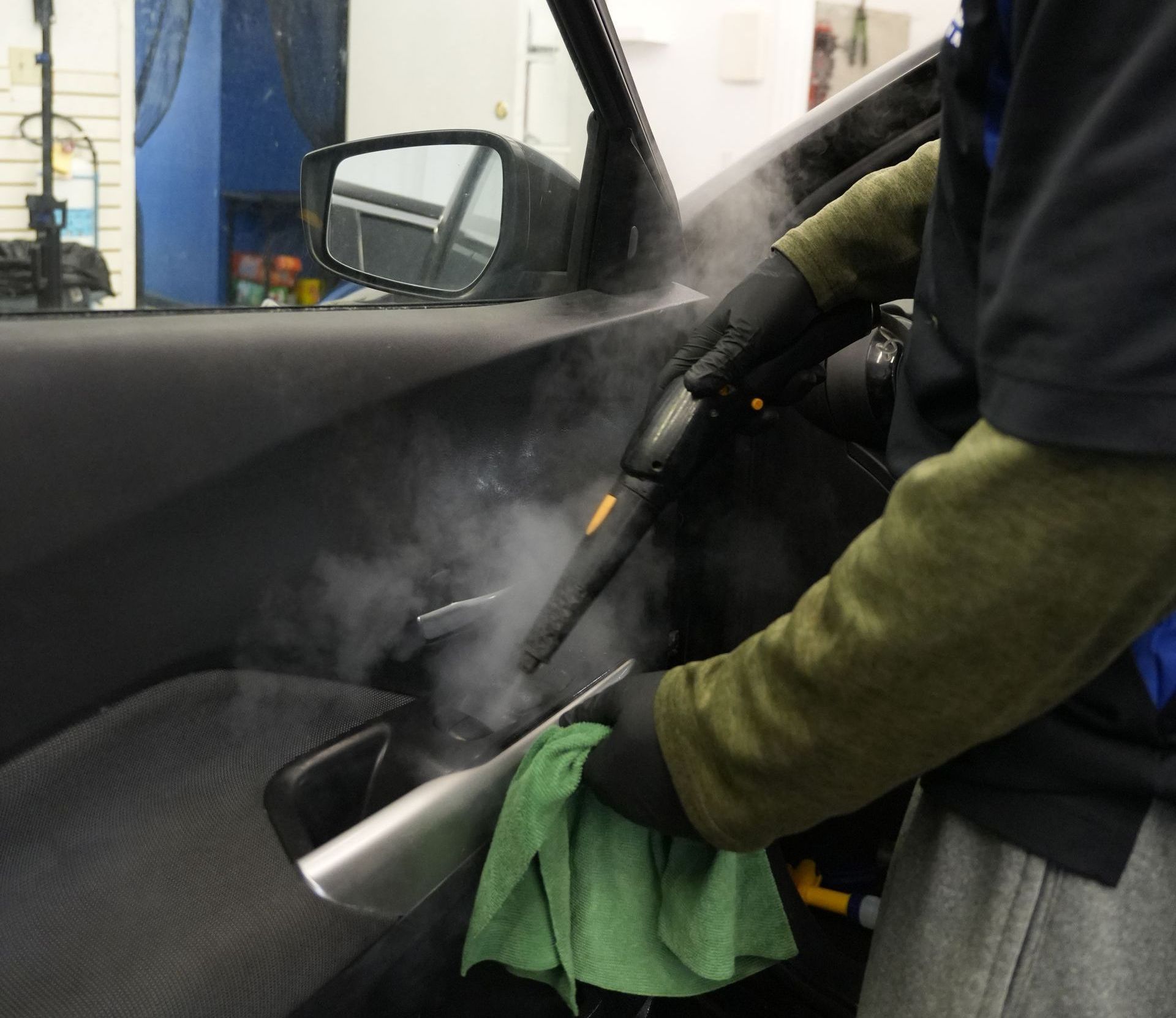 A person is cleaning the seats of a car with a cloth.