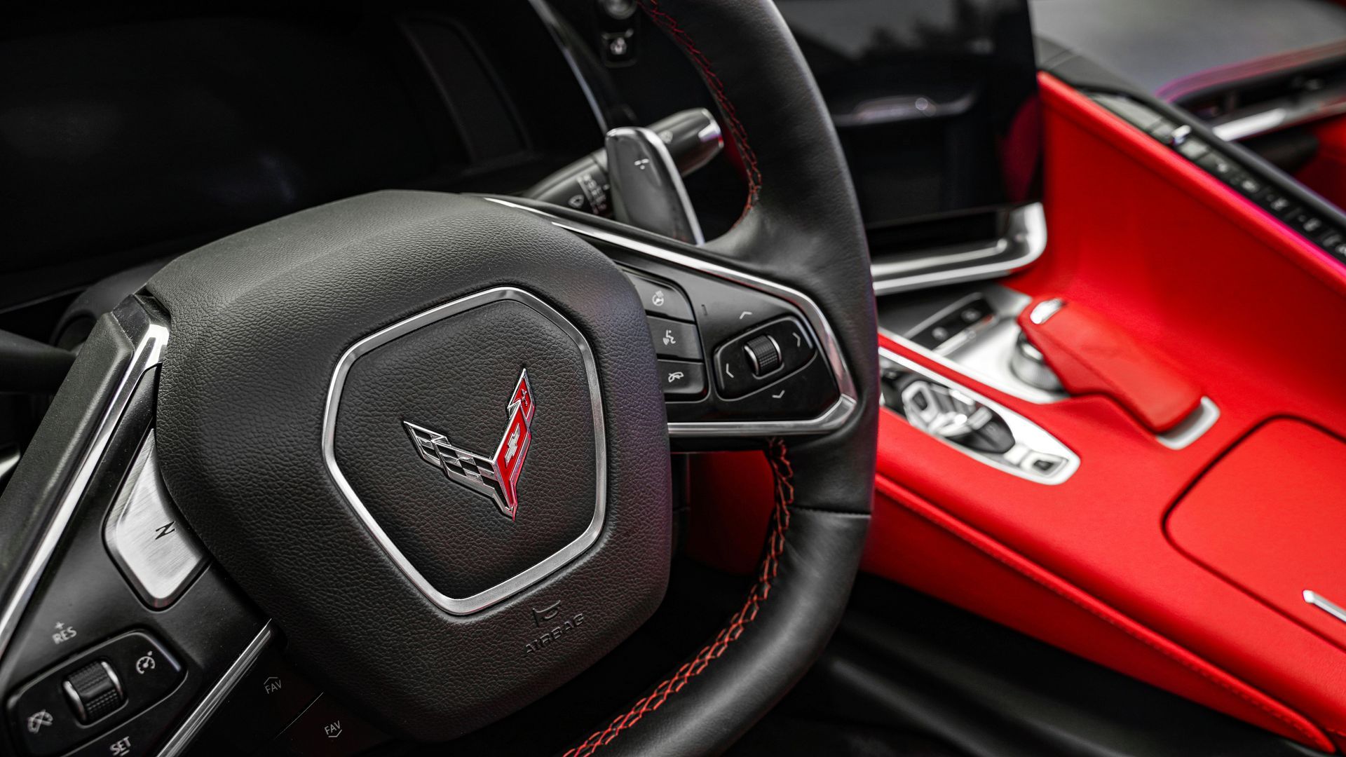 A close up of a corvette steering wheel and dashboard