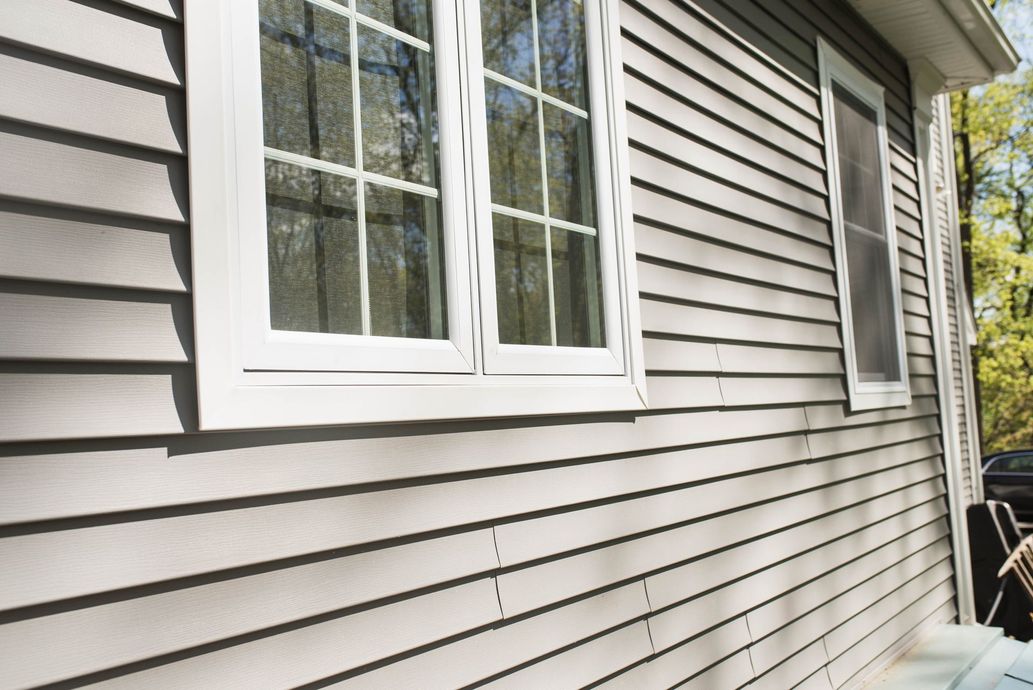 Gray house siding with white-framed windows.