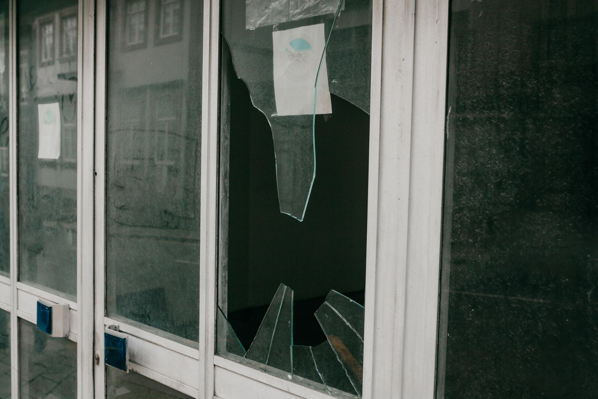 Broken window in a white-framed storefront. 