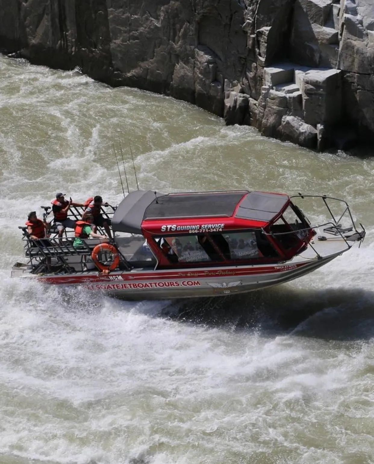 A boat with a red top is going down a river