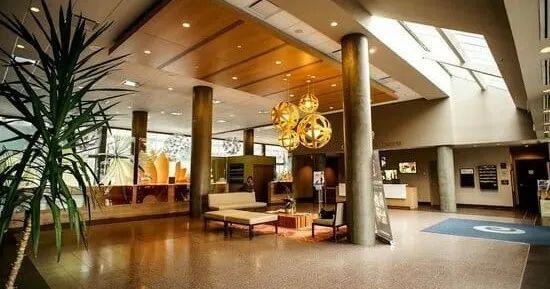 A large lobby of a hotel with a chandelier hanging from the ceiling.