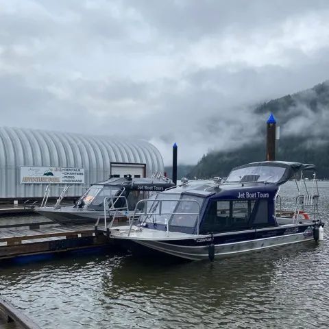 Two boats are docked at a dock on a cloudy day.