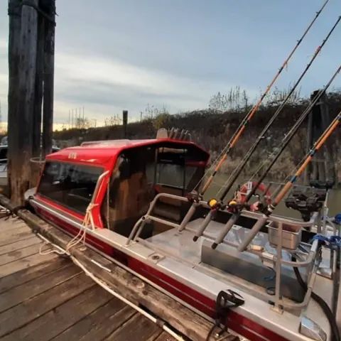 A boat with fishing rods attached to the side of it