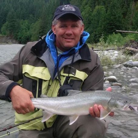 A man is holding a large fish in his hands