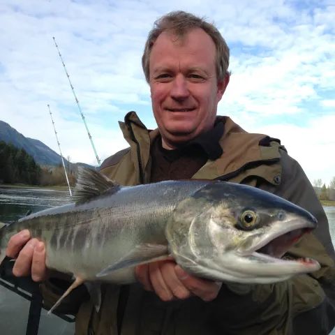A man is holding a large fish in his hands