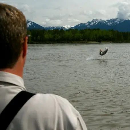 A man is looking at a person jumping into the water.