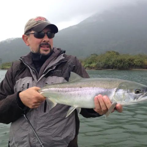 A man is holding a large fish in his hands
